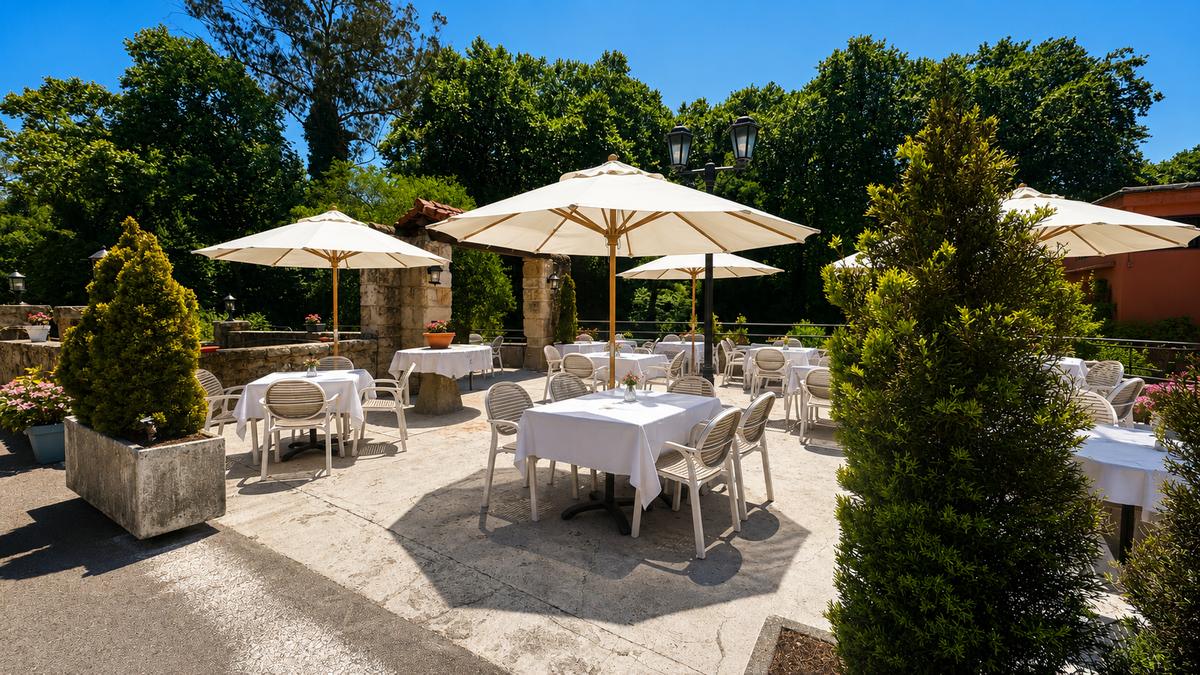 Terraza exterior del Restaurante Paraíso del Pas junto al río Pas, Cantabria